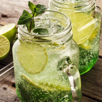 tasty-cold-fresh-drink-lemonade-with-lemon-mint-ice-lime-glass-wooden-table-closeup-scaled.jpg